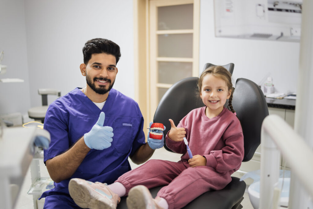 Cheerful dentist guides child in dental hygiene at Sequence Orthodontics.